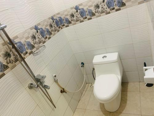 a white bathroom with a toilet and a sink at Doreen Executive Inn in Morogoro