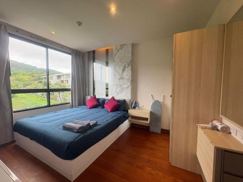 a bedroom with a large bed and a large window at The Lago Nai Harn 2 BR-Walk to beach in Rawai Beach