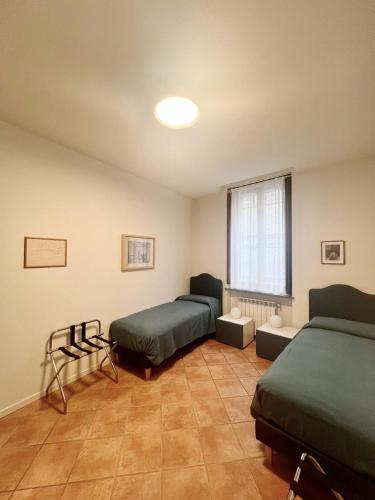 a room with two beds and a window at Appartamento Il glicine Cremona Centro in Cremona