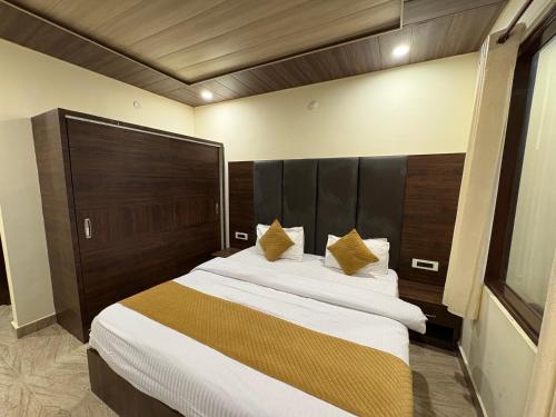 ダルハウジにあるHotel Brownie - Best Selling Hotel In Dalhousieの木製のヘッドボードが付いた大きなベッドのある寝室