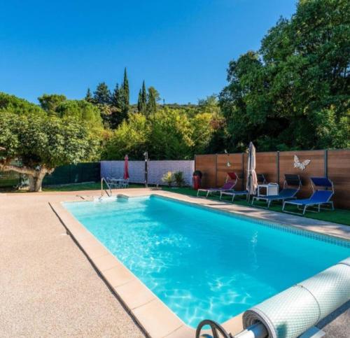 a swimming pool with two lawn chairs at Gite - Chambre d'hôtes indépendante avec Terrasse L'OCCITANIA 60m2 in Saint-Ambroix