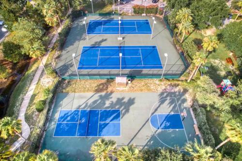 una vista dall'alto di quattro campi da tennis con reti blu di An Emerald Coast Escape a Destin