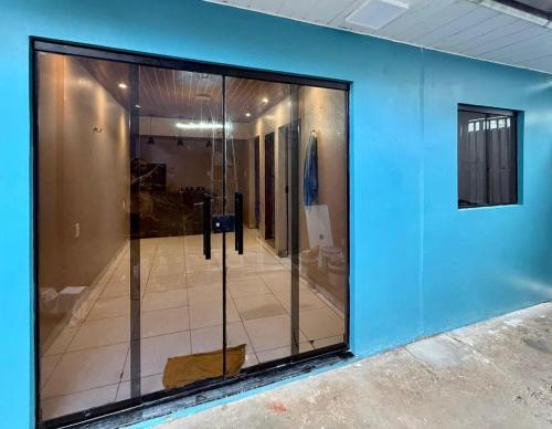 a glass door in a room with a blue wall at Lar Bernardes COP 30 in Belém