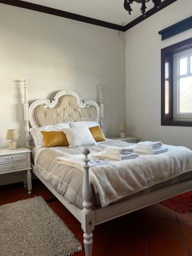 a bedroom with a white bed with gold pillows at Vagos Guest House in Vagos