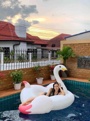 a woman laying on anlatable swan in a pool at Sunset Pool Villa in Na Jomtien