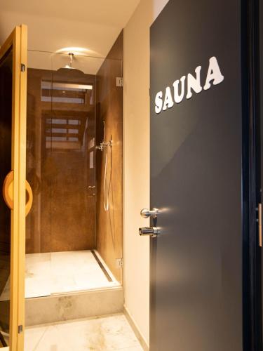 a sign on the door of a bathroom with a shower at Laubennest 1 in Merano