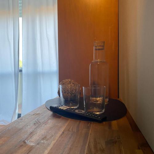 a bottle of water and a glass on a table at Civico 48 in Vizzola Ticino