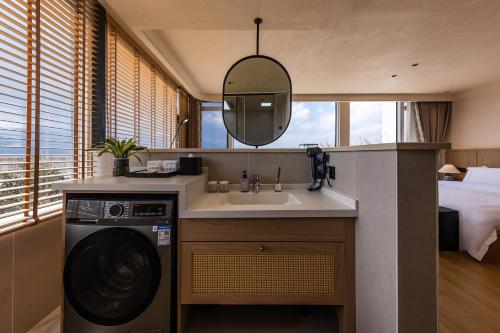 a bathroom with a sink and a washing machine at Tree House Dali 清朴小院 大理 in Dali Airport