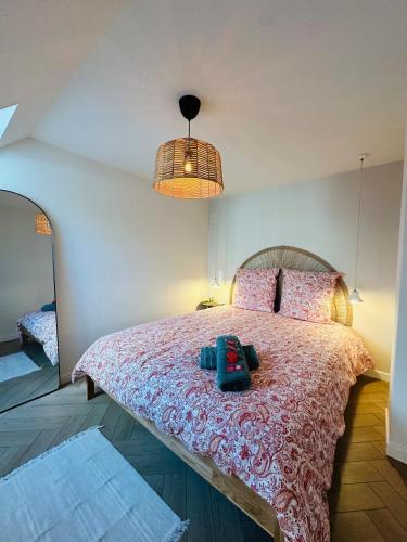 ein Schlafzimmer mit einem großen Bett und einer rosa Tagesdecke in der Unterkunft Auréa - Elégant Duplex Rennes in Rennes