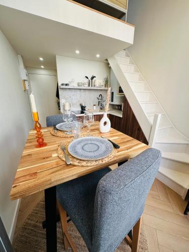einen Esstisch mit 2 Stühlen und eine Treppe in der Unterkunft Auréa - Elégant Duplex Rennes in Rennes