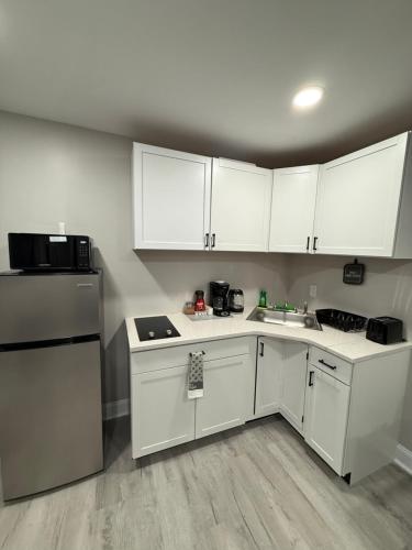 a small kitchen with white cabinets and a sink at New Private Studio JFK in Morris Park