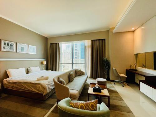 ein Hotelzimmer mit einem Bett und einer Couch in der Unterkunft Modern comfort in a compact spacious studio one or two bedroom retreats in Manama