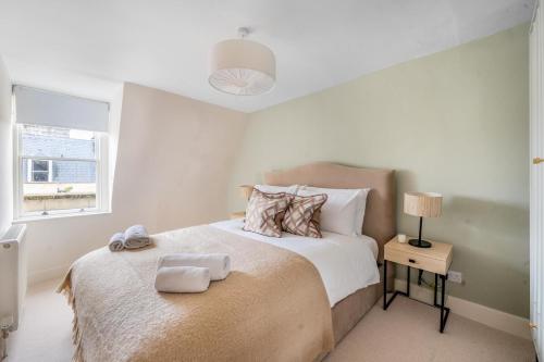 una camera da letto con un letto con due asciugamani sopra di Boutique Bath Apartment, Minutes from Shops & Spas a Bath