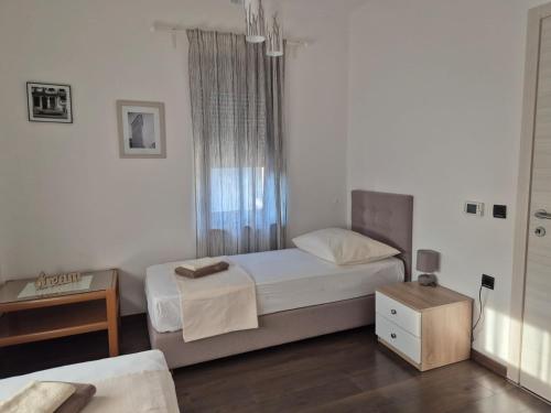 a small bedroom with a bed and a table at Apartmani Nika in Rijeka