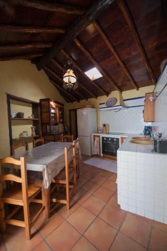 a kitchen with a table and chairs and a kitchen with a refrigerator at Casa Vidal in Guía de Isora