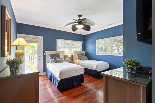 a blue room with two beds and a ceiling fan at AB15: 15 Atlantic Beach in Kiawah Island