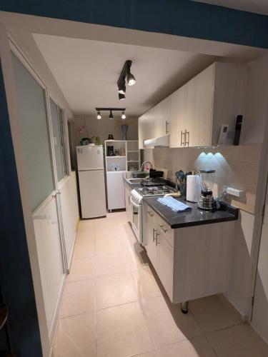 a kitchen with a stove and a refrigerator at Departamento cerca del Zocalo y aeropuerto in Mexico City