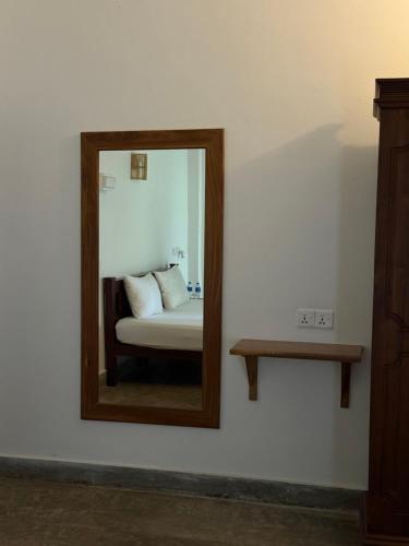 a mirror on a wall with a bed in a room at Riverside Cabanas in Mirissa