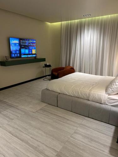 a bedroom with a bed and a flat screen tv at ovation Studio in Riyadh