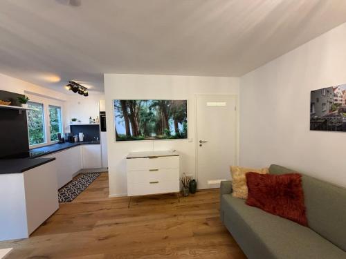 a living room with a couch and a tv at Hochwertige GoldenKey Suite mitten in der Altstadt in Augsburg