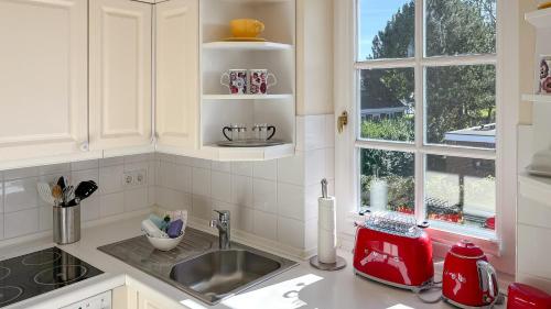 a kitchen counter with a sink and a window at Heefwai in Morsum