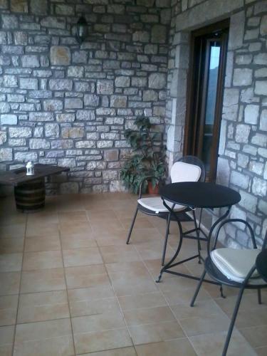 a table and chairs in a room with a stone wall at Elova in Zátouna