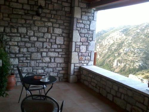 a patio with a table and chairs and a window at Elova in Zátouna
