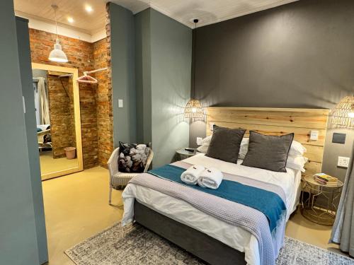 a bedroom with a large bed with towels on it at CityScape Nest Suite Unit 2 in Mossel Bay
