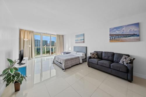 a living room with a couch and a bed at Miami Beach Paradise-Ocean View Apartments -Free Parking in Sunny Isles Beach