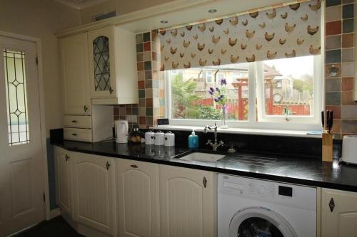 eine Küche mit Waschmaschine und Fenster in der Unterkunft Milton House Chesterfield By Smart Corporate Stays in Chesterfield