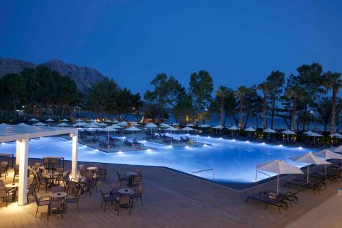 a large swimming pool with tables and chairs at Paleros Beach Resort in Paleros