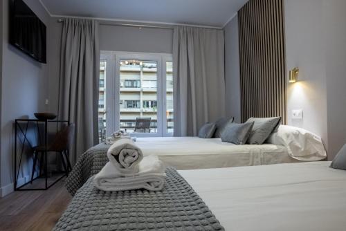 a hotel room with two beds and a balcony at Casa Ollerias by ChicStays in Córdoba