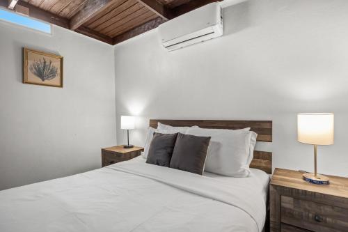 AibonitoにあるPrivate Pool Pet-friendly Steps To The Beachのベッドルーム1室(白いシーツとランプ2つ付)