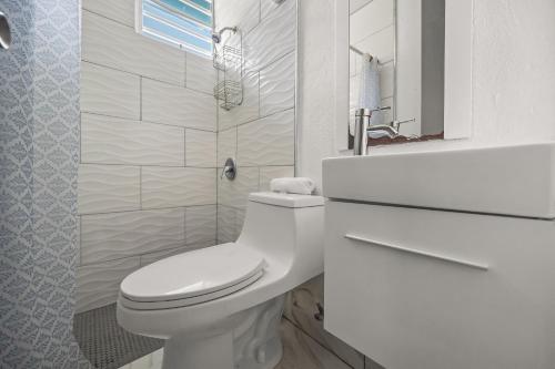 AibonitoにあるPrivate Pool Pet-friendly Steps To The Beachのトイレと洗面台を備えた白いバスルーム