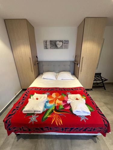 a bedroom with a bed with a red blanket at Studio Climatisé avec Réservoir d'eau in Saint-François