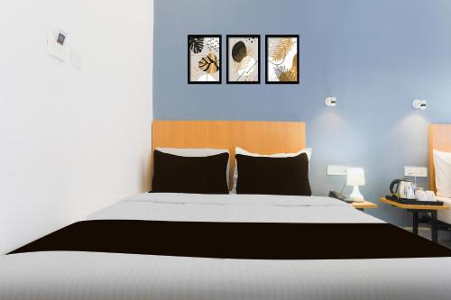 um quarto com uma cama com três fotos na parede em Hotel O Vivek inn Palace em Prayagraj