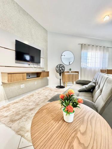 un salon avec un canapé et une table dans l'établissement Apartamento Premium Cama Queen Ar Cond centro cidade, à Formosa