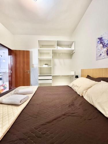 une chambre avec un grand lit et des étagères dans l'établissement Apartamento Premium Cama Queen Ar Cond centro cidade, à Formosa