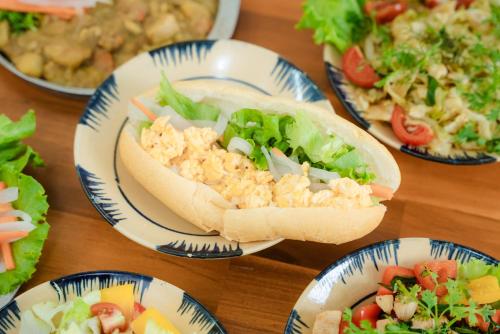 een tafel vol borden met eten, waaronder een sandwich en salade bij An house Ninh Binh in Ninh Binh