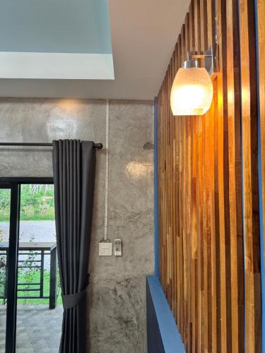 a bathroom with a shower curtain and a window at ใสโพธิ์โฮมสเตย์ in Phatthalung