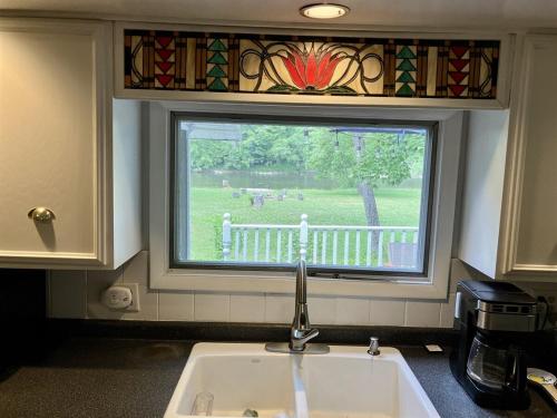 a kitchen sink with a window with a view of a yard at Golden Valley Retreat in Hersey