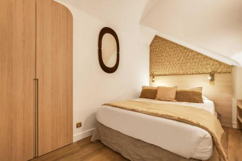 BEAUFITUL APMT - AC -2BR-6P- NOTRE DAME في باريس: غرفة نوم بها سرير كبير ومرآة