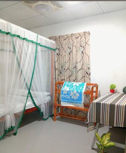 a room with a bed and a chair and a curtain at Dream Image in Midigama East