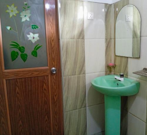 a bathroom with a green sink and a mirror at Dream Image in Nikawatawana