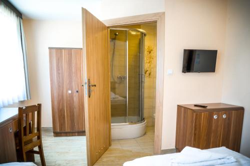 Łazienka z prysznicem i szklanymi drzwiami w obiekcie Kompleks Hotelarski Zgoda w mieście Świętochłowice
