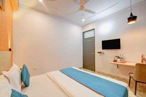 a bedroom with a bed and a desk and a tv at Collection O South City 1 Arcadia in Gurgaon
