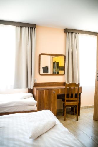 a bedroom with two beds and a desk with a mirror at ZGODA Kompleks Hotelarski in Świętochłowice