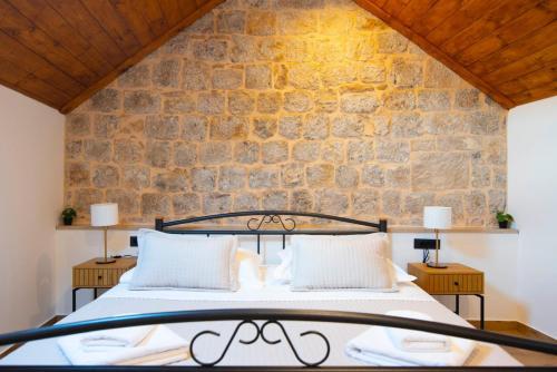 una cama en una habitación con una pared de piedra en Luxury apartments White house, en Sinj