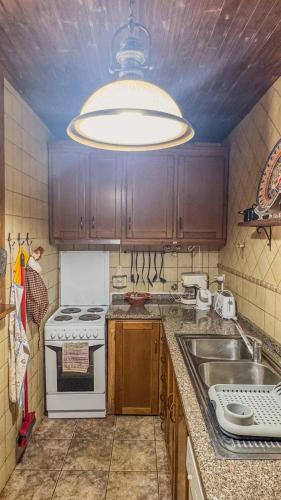 a kitchen with a stove and a sink and a light at Ninho do Melro - Turismo Rural Bragança in Bragança