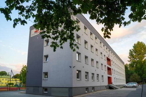 a large white building with a car parked in front of it at ZGODA Kompleks Hotelarski in Świętochłowice